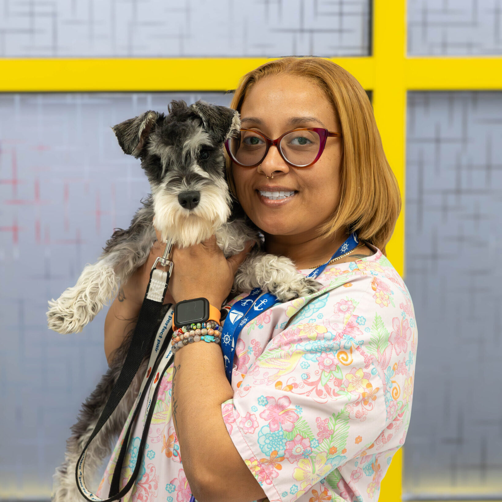 woman smiling and holding schnauzer dog