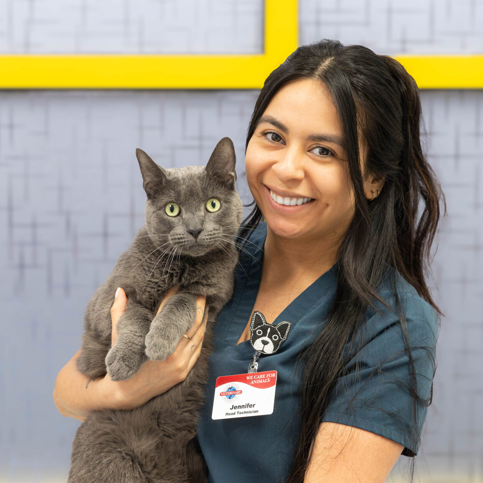 Jen M. Head Technician And Client Relations Manager woman smiling and holding grey cat