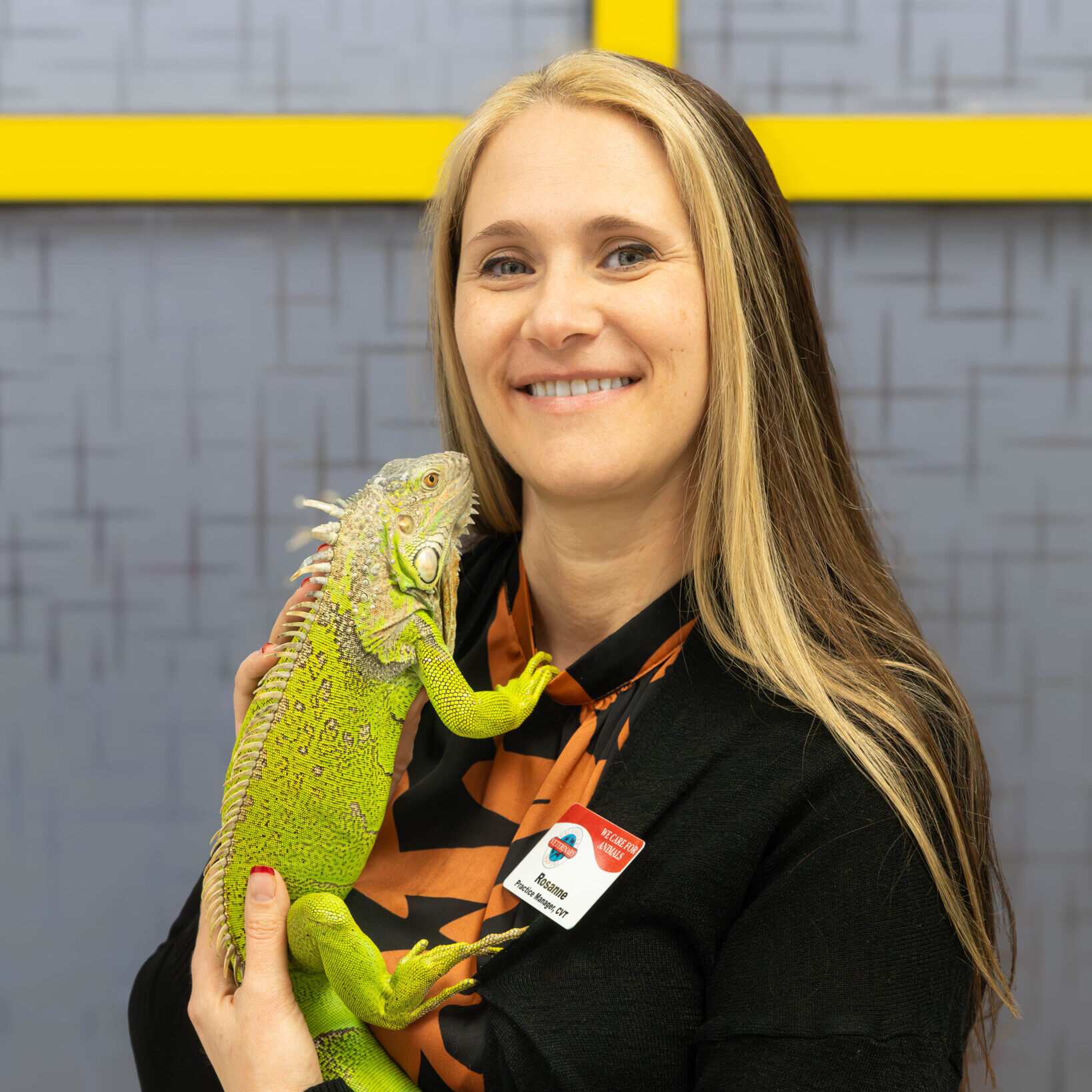 Rosanne Cvt, Practice Manager Woman smiling and holding a green iguana