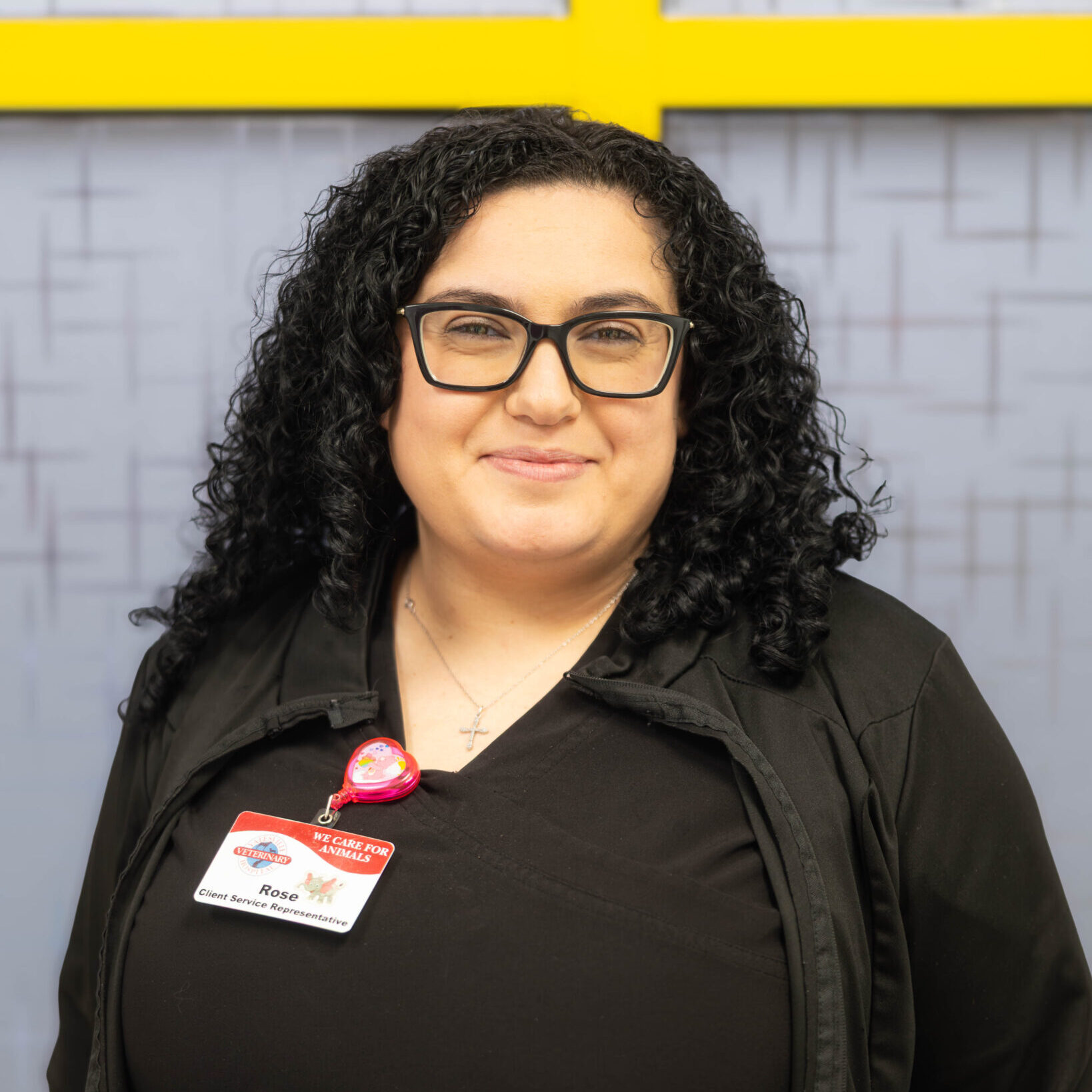 Woman with black hair and glasses smiling